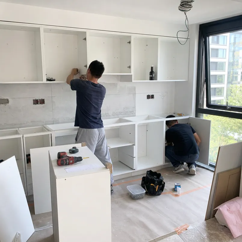 Kitchen renovation contractor installing melamine MDF cabinet carcasses on residential development site