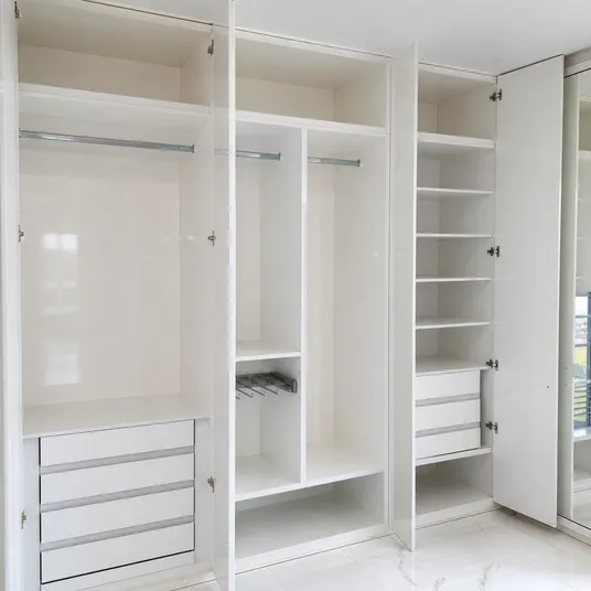 Glossy melamine plywood wardrobe interior with shelving and hanging rails